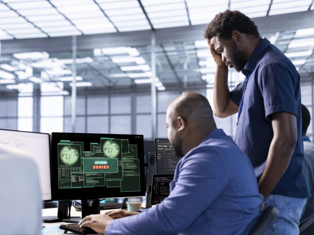 Upset coworkers in data center getting access denied, doing face palm gesture