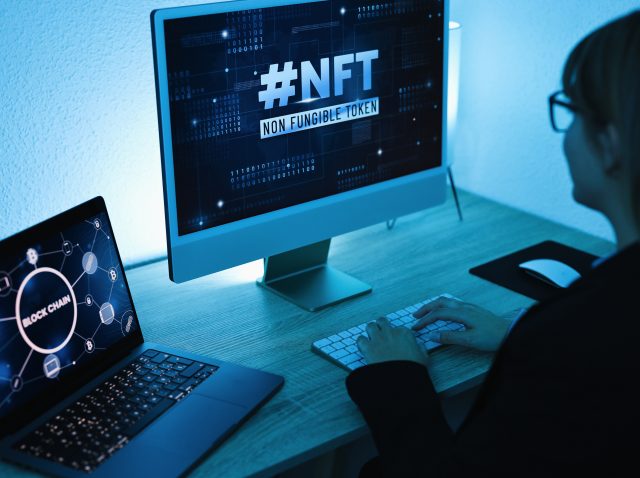 Young woman buying NFT on Blockchain market - New Technology Token Concept - Focus on right computer screen