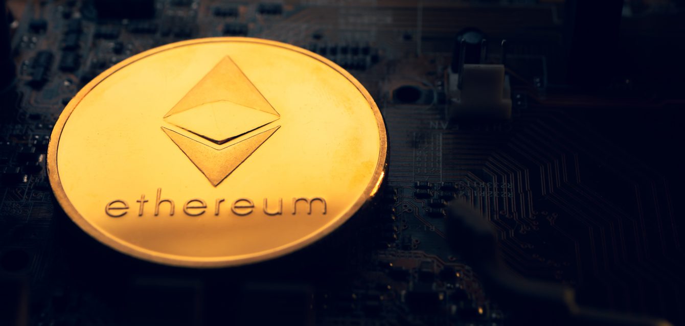 A golden coin with ethereum symbol on a mainboard.