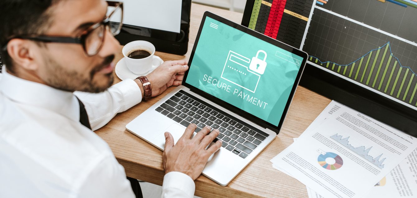 selective focus of bi-racial trader using laptop with secure payment letters