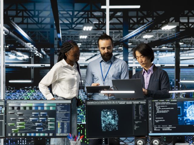 Team of data center coworkers in office running AI forecasting simulations