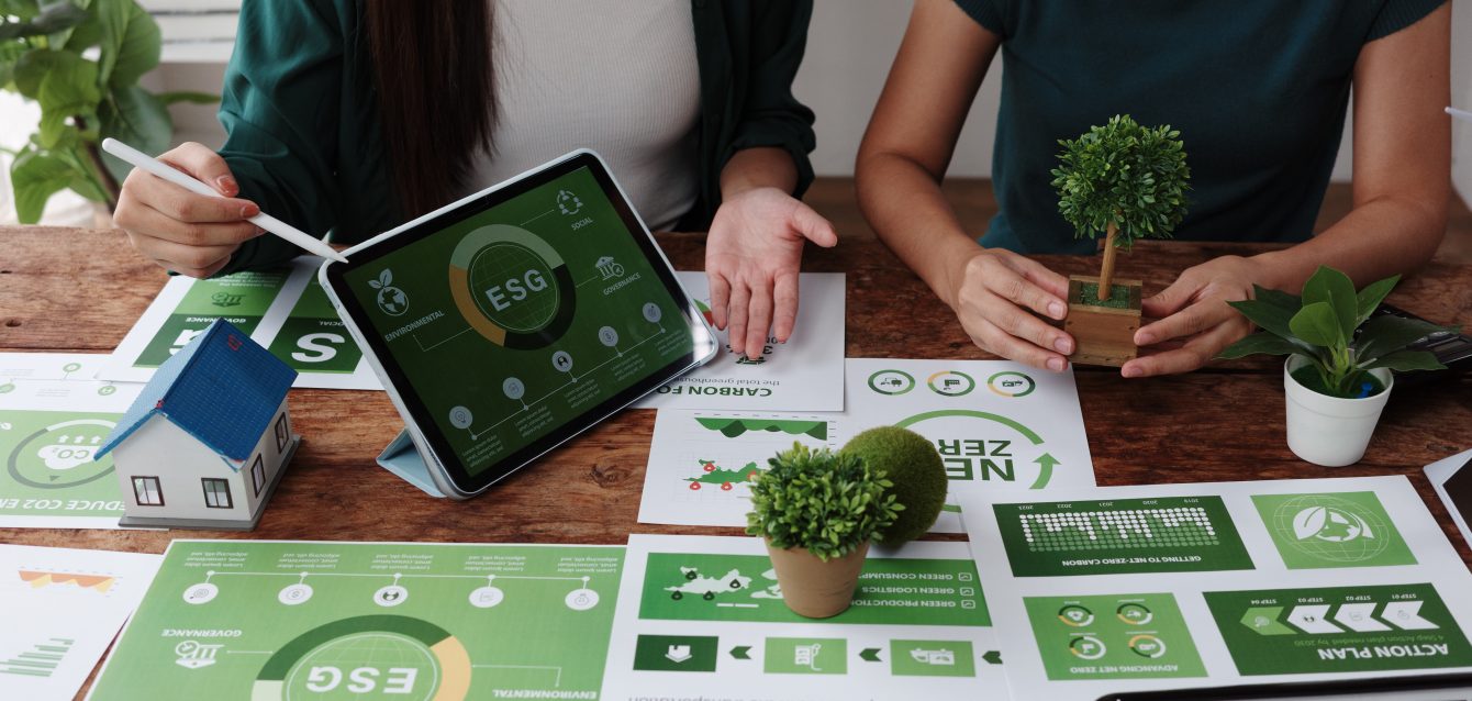 Businesswomen planning environmental social and governance strategy using tablet and charts